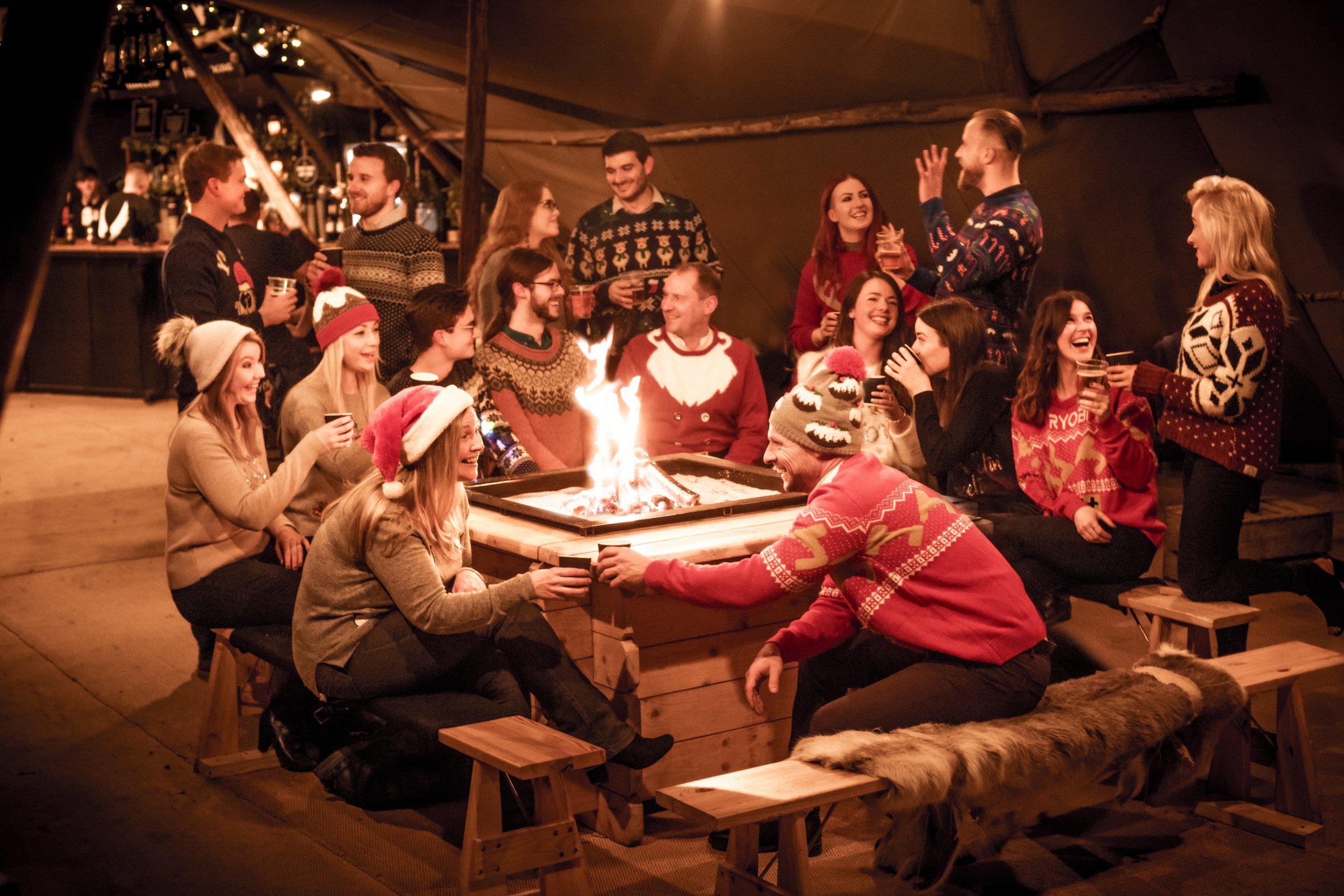 The Staff of We Are Boutique Gathered Around a Fire Wearing Christmas Jumpers 